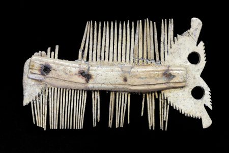 Double-sided bone comb with one end made to look like the face of an owl.