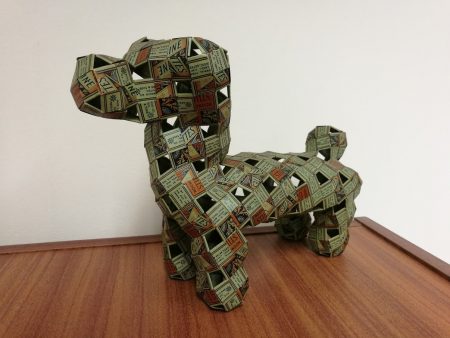 Model of a dog made of interwoven strips of Wills cigarette packets.